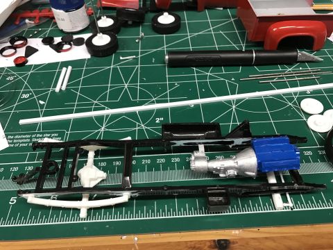 1989 Ford Bronco - Model car parts laid out on a cutting mat, including a chassis, engine, and wheels.