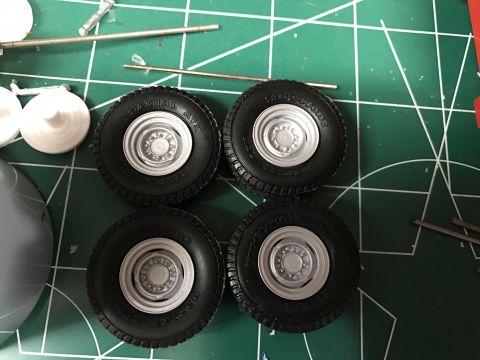 1989 Ford Bronco - Model kit tires and wheels are laid out on a green cutting mat with various tools.