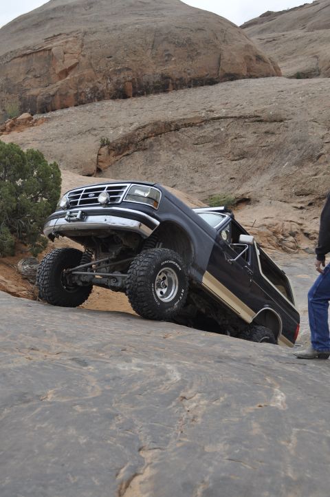 1991 Ford Bronco - This 1991 Ford Bronco is navigating a challenging off-road trail with steep rock formations.