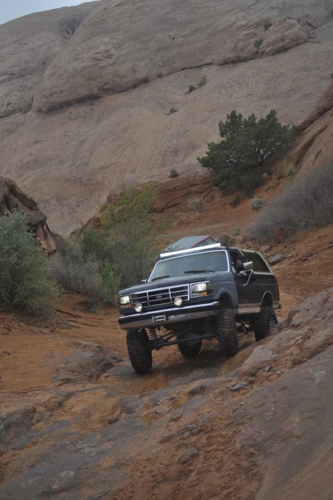 1991 Ford Bronco - This 1991 Ford Bronco navigates a challenging off-road path in a desert landscape.