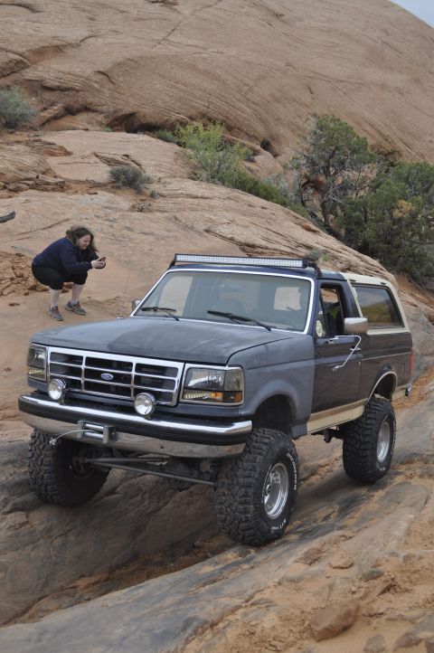 1991 Ford Bronco - This 1991 Ford Bronco navigates rocky terrain, equipped with a light bar for off-road adventures.