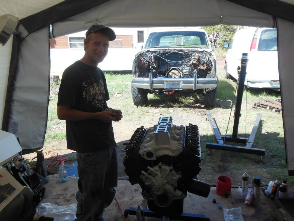 Engine on stand in front of disassembled truck