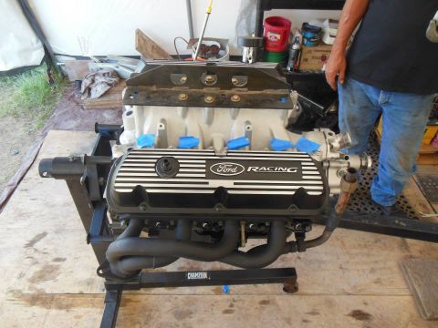 1984 Ford Bronco - Engine with Ford Racing valve covers on a stand, possibly for a Bronco.