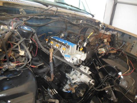 1984 Ford Bronco - Close-up view of a vehicle's engine bay, highlighting a newly installed engine with visible fuel injectors and extensive wiring.