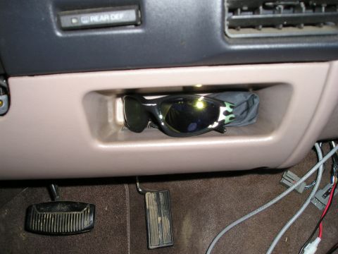1996 Ford Bronco - A pair of sunglasses rests in a small compartment inside the vehicle's cabin.