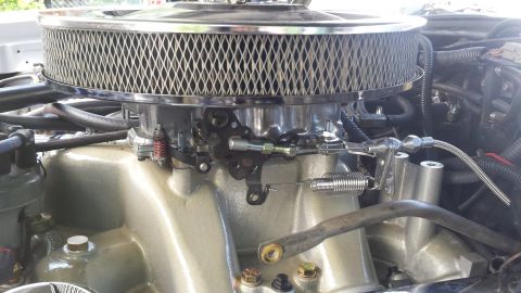 1976 Ford Ranchero - Close-up of an engine's intake system, a chrome air filter and throttle linkage.