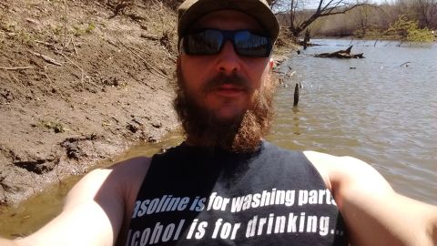 1994 Ford Bronco - Man in water wearing a t-shirt with text about gasoline and alcohol.