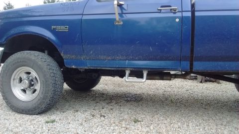 1996 Ford F-350 - Side view of a blue 1996 Ford F-350 pickup truck, focusing on the door and running board.