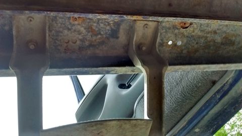 1996 Ford F-350 - The underside of a truck bed shows some rust and wear, with a glimpse of the interior visible.