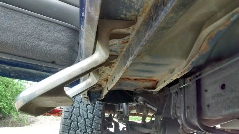 1996 Ford F-350 - Underside view of a truck's frame and running board, showing signs of rust.