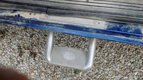 1996 Ford F-350 - A "BULLY" branded step bar is attached to the side of a blue vehicle.