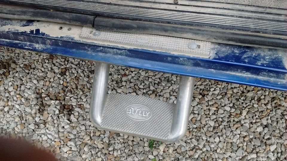 Step bar with "BULLY" logo on a blue vehicle