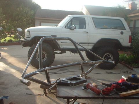 1996 Ford Bronco - Custom roll cage parts are laid out in front of a white 1992 Ford Bronco.