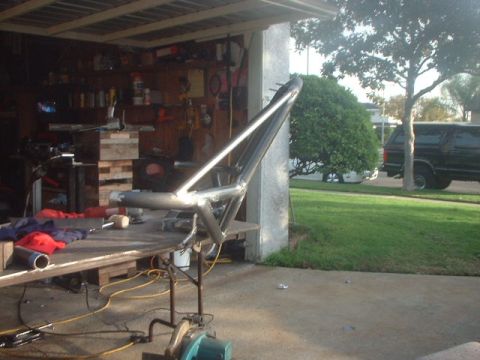 1996 Ford Bronco - A metal frame is being worked on in a garage, with a black SUV visible in the background.