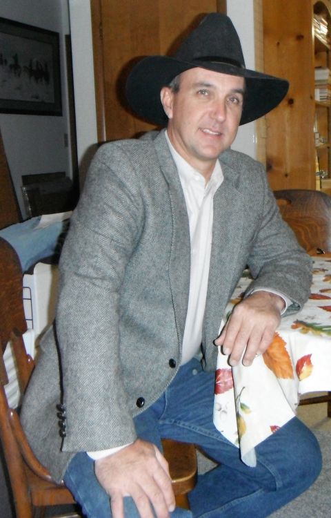 2000 Ford F-250 - A man in a cowboy hat and blazer is seated at a table, holding a napkin with a fall leaf pattern.