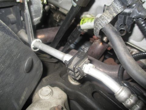 2004 Ford Crown Victoria - Close-up view of engine bay components, including metal tubing and electrical wiring, with a sensor attached to a pipe.