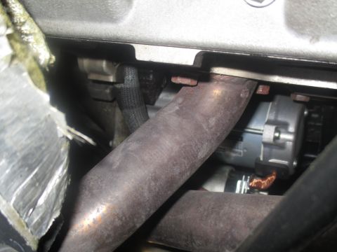 2004 Ford Crown Victoria - Close-up view of an engine starter motor and exhaust manifold components.