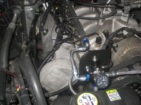 2004 Ford Crown Victoria - Close-up of engine bay components, including a fuel pressure regulator and alternator.