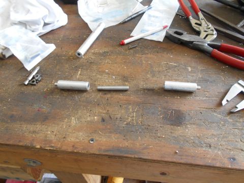 1992 Ford Bronco - Various metal components and springs are arranged on a workbench, suggesting a repair or assembly process.