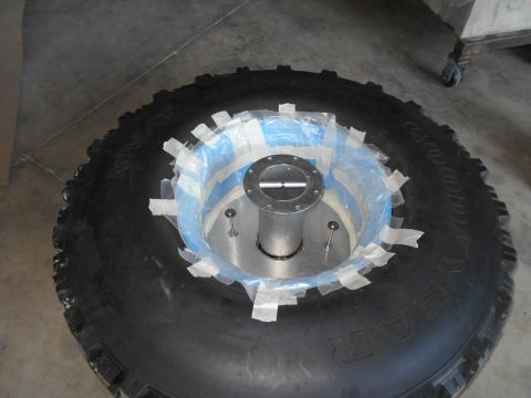1992 Ford Bronco - Tire with a hub adapter, taped in place for modification or measurement.