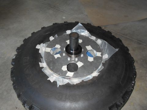 1992 Ford Bronco - A tire with a metal plate and hub assembly is shown, possibly for a vehicle modification.