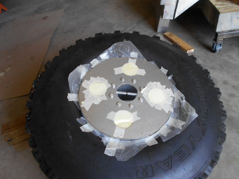 1992 Ford Bronco - A tire with a metal disc, possibly a wheel hub, is taped and secured with putty.