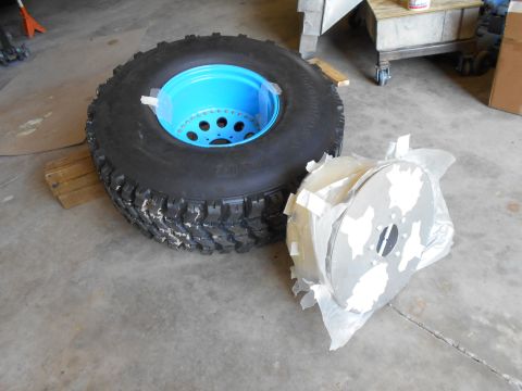 1992 Ford Bronco - A tire and wheel assembly with a bright blue rim sits next to a package of brake rotors.