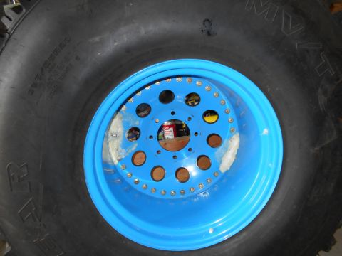 1992 Ford Bronco - A close-up view of a blue beadlock wheel and a large tire, revealing details of the wheel's construction and tire markings.