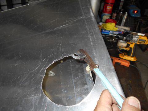 1992 Ford Bronco - Cutting a hole in a metal panel with tin snips, tools in background.