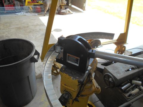 1992 Ford Bronco - A metal bending machine is shown in a workshop setting with a trash can and a yellow support structure.