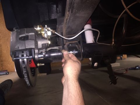 1982 Ford Bronco - A mechanic's hand is shown adjusting a brake caliper on the rear passenger side of a vehicle. The vehicle appears to be a classic SUV or tr…