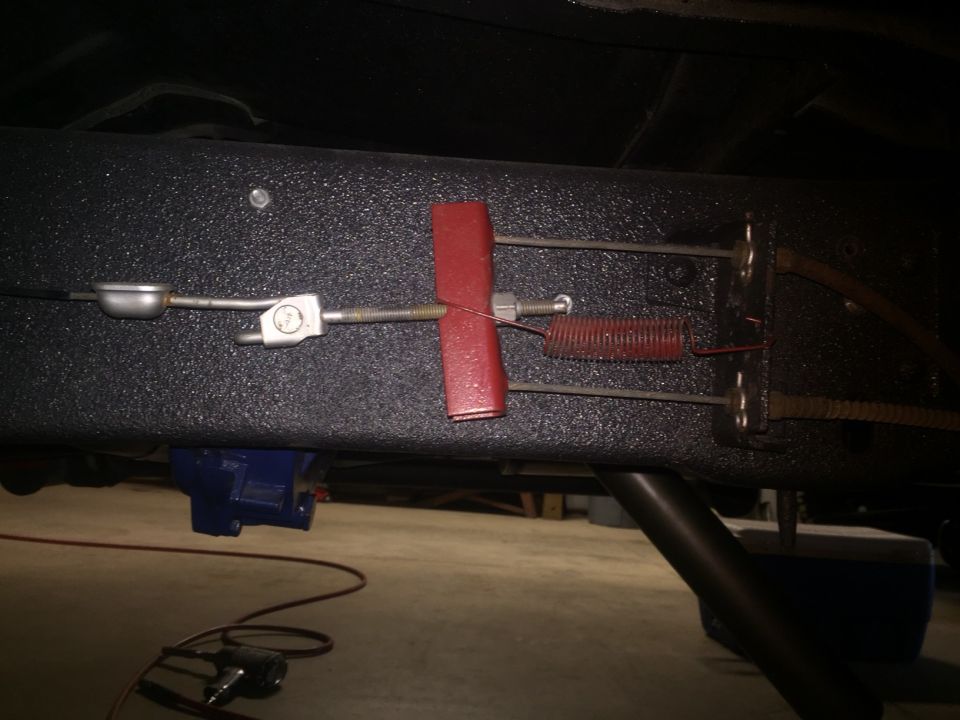 Undercarriage view of parking brake cable mechanism and blue actuator.