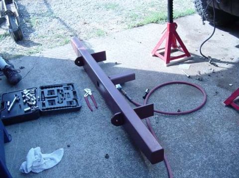 1996 Ford Bronco - Tools and an aftermarket bumper are laid out on the ground, possibly for installation.
