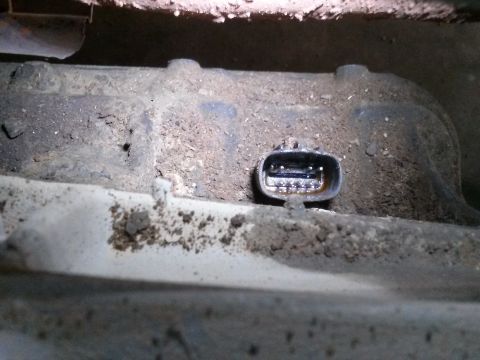 1996 Ford Bronco - A close-up view shows a dirty electrical connector with multiple pins, likely part of a vehicle's sensor system. The connector is embedded…