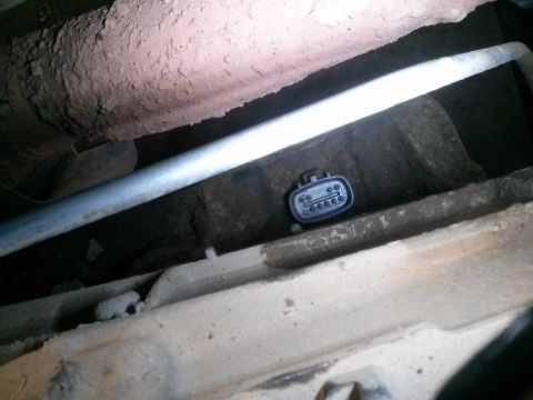 1996 Ford Bronco - A black electrical connector with six pins is visible in the undercarriage of a vehicle, possibly a 1996 Ford Bronco. The connector is situ…