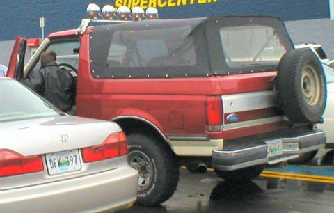 1996 Ford Bronco - This red Ford Bronco features a removable soft top and a spare tire mounted on the rear tailgate.