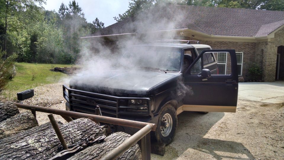 After a couple of hours winching logs onto the trailer at high idle (to keep the alternator charging), all the coolant came out.  It took nearly 2 gallons to refill after it cooled.  I really need to switch back to a clutch fan.