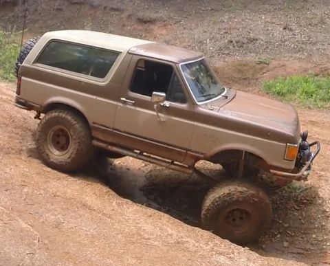 1988 Ford Bronco - A lifted 1988 Ford Bronco, nicknamed "Mr Hyde the Deuce", navigates a muddy off-road trail. The two-tone brown and tan SUV is equipped with…