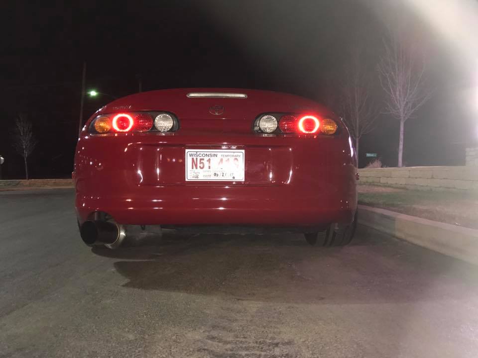 Red 1994 Toyota Supra rear view with illuminated taillights and Wisconsin license plate