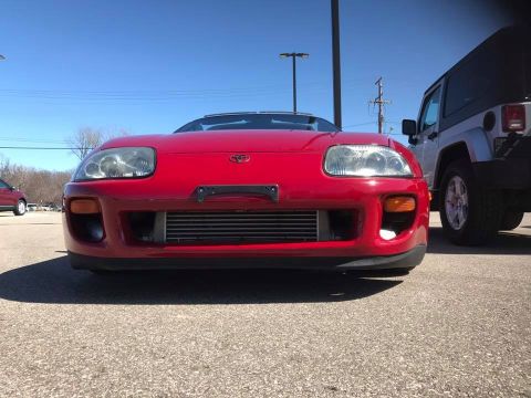 1994 Toyota Supra - Front view of a red 1994 Toyota Supra, an aftermarket intercooler visible behind the grille.