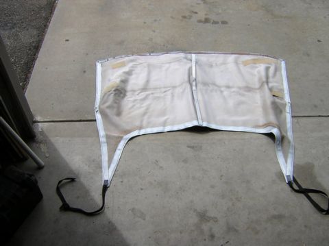 1996 Ford Bronco - The interior of a vehicle's soft top frame is visible, lying on a concrete surface.