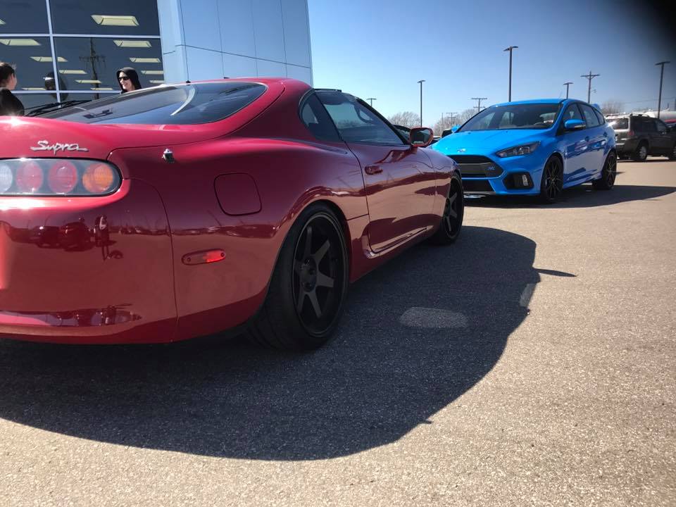 Red 1994 Toyota Supra parked next to a blue Ford Focus