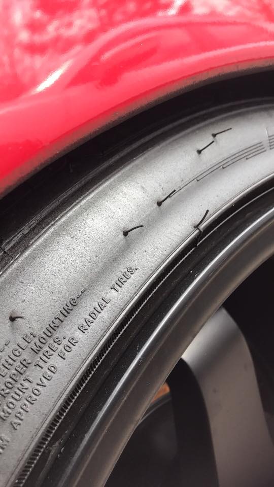 Red car fender over tire with text 'FOR RADIAL TIRES.'