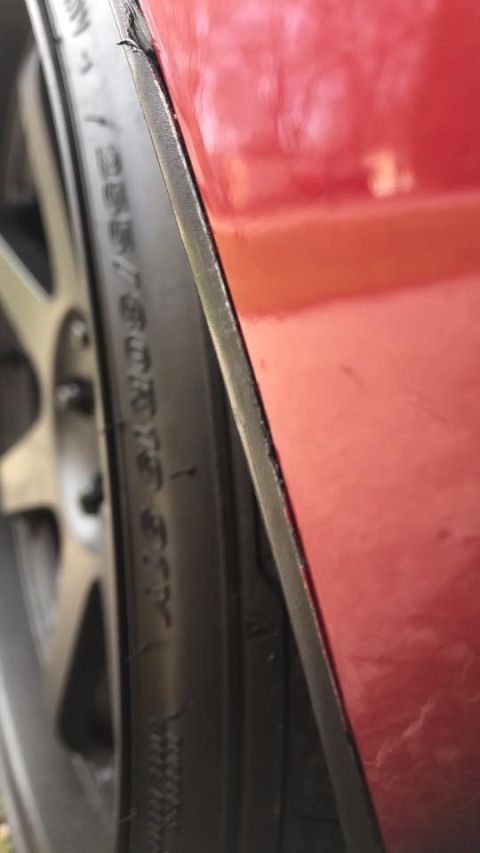 1994 Toyota Supra - Close-up of a red car's wheel well, showing the tire and part of the rim.