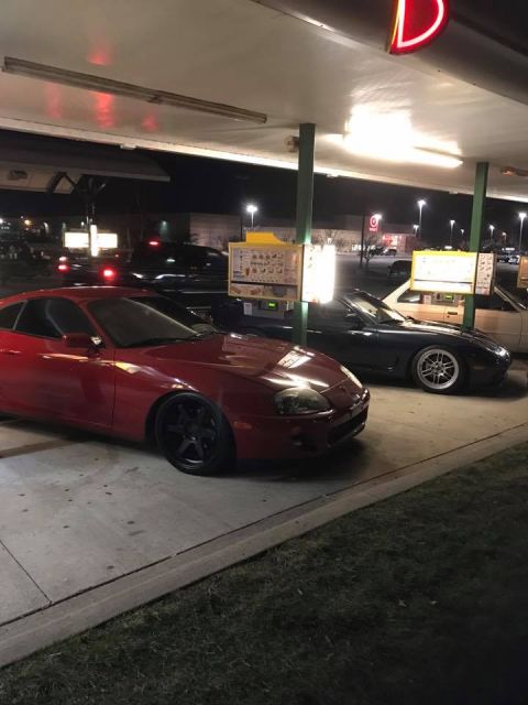 1994 Toyota Supra - A red sports car is parked at a drive-thru, with another car visible behind it.