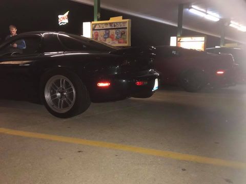 1994 Toyota Supra - A black Mazda RX-7 FD is parked at a drive-in restaurant at night, with another car visible behind it.