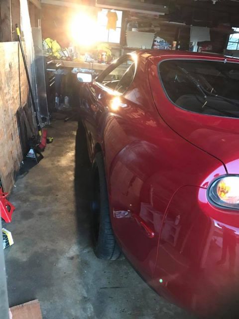 1994 Toyota Supra - Red car's rear quarter panel and taillight are visible in a cluttered garage setting.