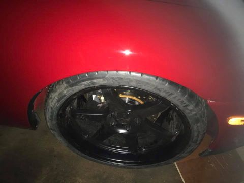1994 Toyota Supra - Close-up of a red car's wheel and tire, showing aftermarket modifications.