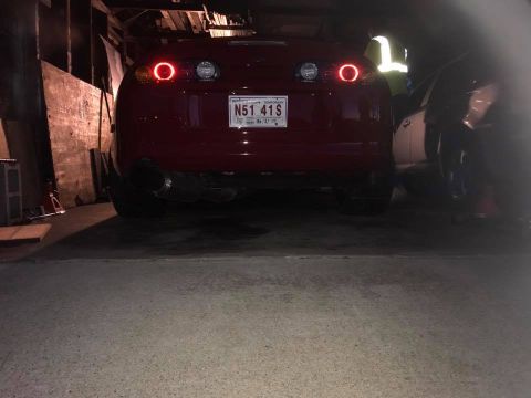1994 Toyota Supra - Rear view of a red Toyota Supra with distinctive circular taillights and a large exhaust pipe.