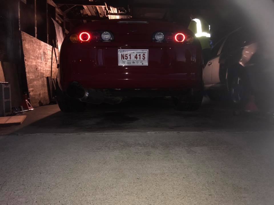 Red Toyota Supra with aftermarket exhaust, circular taillights, and license plate N51 41S